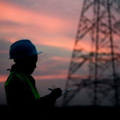 Worker by an electricity pylon