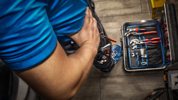 Image showing a box of tools at the feet of a self employed worker