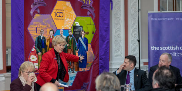 Scottish Co-operative Party Chair Rita Miller pointing to Mary Barbour on our banner