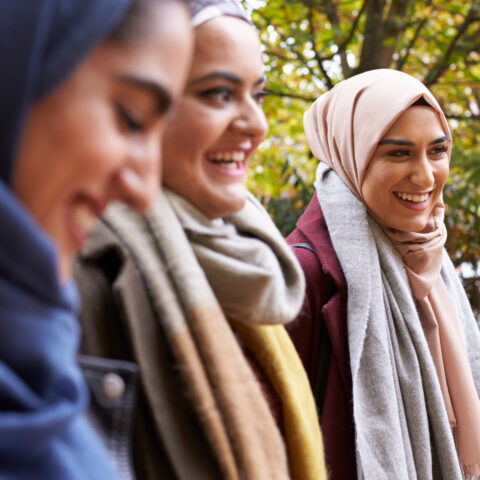 British Muslim Female Friends Meeting In Urban Environment