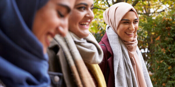 British Muslim Female Friends Meeting In Urban Environment