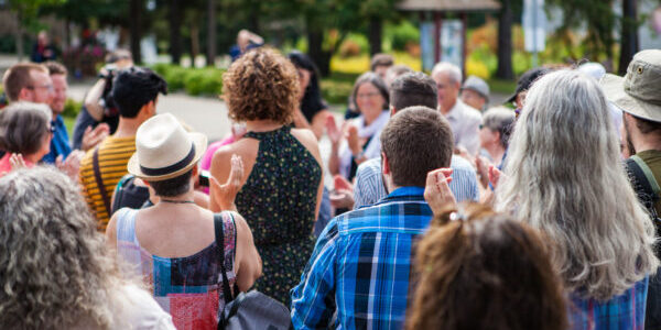 100 People applauding to a public speech given outdoors in the v
