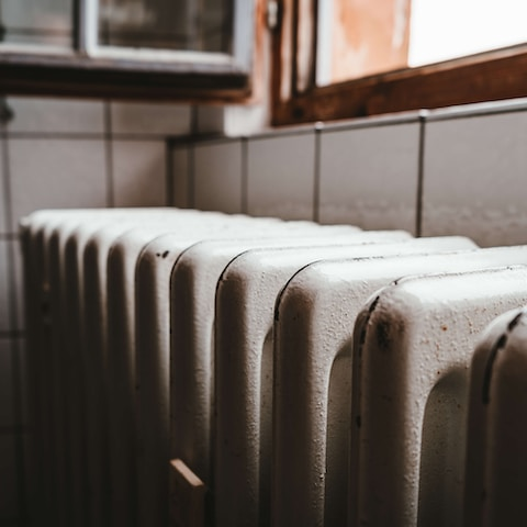 white radiator heater beside brown wooden window
